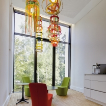 Die Teeküche mit raumhoher Fensterfront lädt zur Pause ein. Die farbigen Monopod-Sessel und vom Kunden selbst entworfenen bunten Hängeleuchten bringen Farbe in den Raum. Die Teeküche mit raumhoher Fensterfront lädt zur Pause ein. Die farbigen Monopod-Sessel und vom Kunden selbst entworfenen bunten Hängeleuchten bringen Farbe in den Raum.